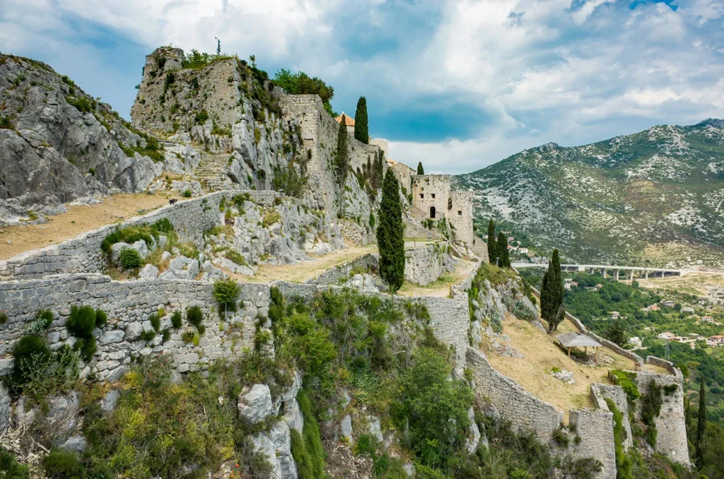 Fortress of Klis, Split Croatia. Beautiful old ruins and buildings on high mountain top over the Adriatic Sea. Nice architecture of stone constructions. Ancient Royal Castle.