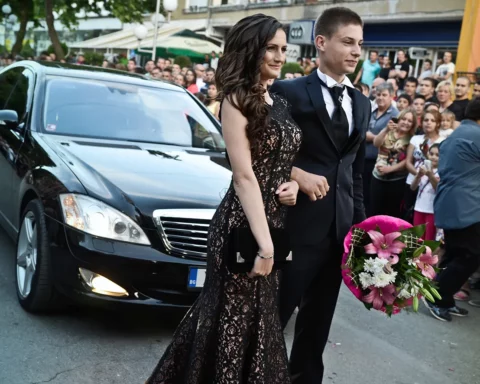 Promotion balls season kick starts in Bulgaria. A young couple walks hand in hand during the high school graduates parade through the Bulgarian town of Svilengrad, Bulgaria on May 26, 2015.