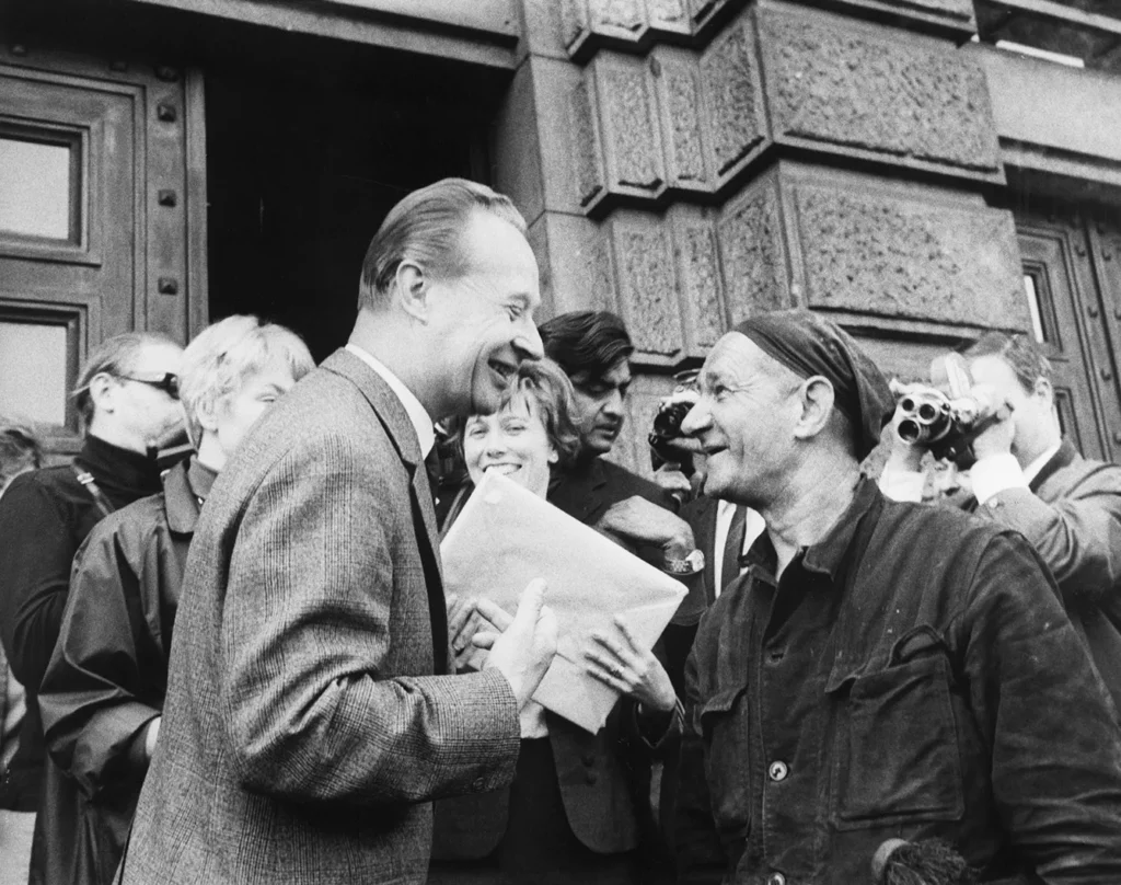 Alexander Dubcek with Supporter. Mr. Alexander Dubcek, first secretary of the Central Committee of the Communist Party of Czechoslovakia smiles as he chats with a chimney sweep in front of the Communist Party building here yesterday before entering, 9/12/1968, Prague