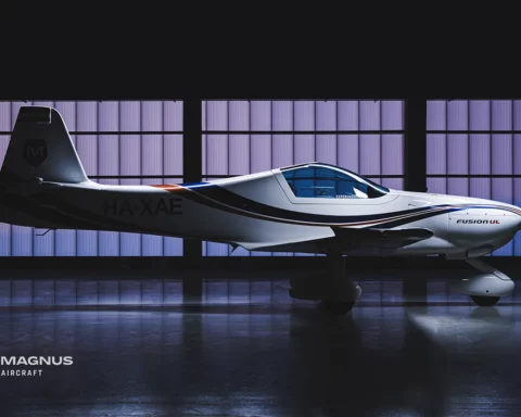 The magnus aircraft company's plane stands in a dark hangar with a neon side.