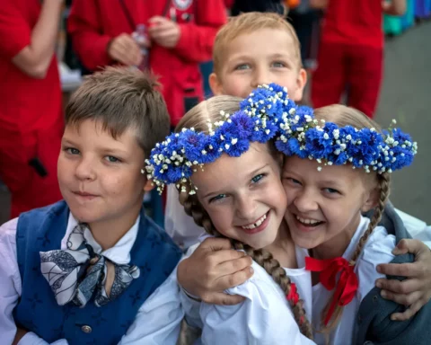 Riga, Latvia - July 12, 2015: XI Latvian School Youth Song and Dance Festival. Concert in Mezaparks “You in my song”. Two young participant boys and girls are posing for the camera. The girls are holding each other.