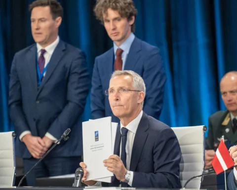 NATO Secretary General Jens Stoltenberg holds the NATO Innovation Fund Letter of Commitment.