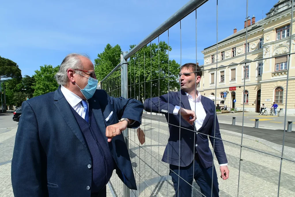 The City Of Gorizia Is Divided In Two. Mayor of Gorizia Rodolfo Ziberna and Mayor of Nuova Gorica Klemen Miklavic meet in Piazza Transalpina through wire mesh that divides Piazza Transalpina (Transalpina Square) on May 8, 2020 in Gorizia, Italy. Piazza Transalpina is a square divided between the municipalities of Gorizia in Italy and Nova Gorica in Slovenia. In 1947, the new border created between Italy and Yugoslavia was traced by dividing the square in two, crossed by the so-called "Muro di Gorizia". From May 1, 2004, with the entry of Slovenia into the European Union, the wall dividing the square was removed, but from March 11, 2020 the Slovenian government closed its borders with Italy to counter the spread of the coronavirus. A wire mesh has been positioned on the square to delimit the border between Italy and Slovenia, dividing many families, friends and couples.