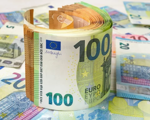 Roll of 100 and 50 euro paper banknotes over money background.