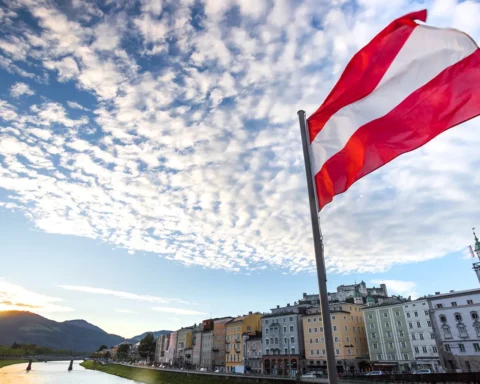 Austrian flag over historic salzburg cityscape.