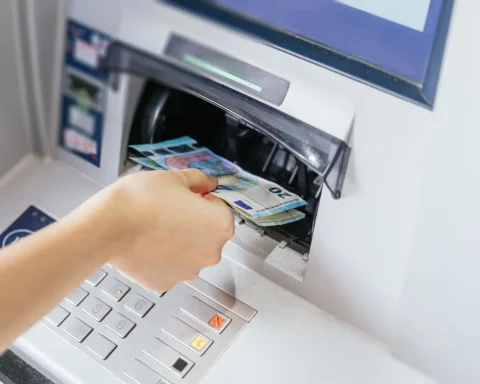 hand withdrawing cash, euro bills from the ATM bank machine.