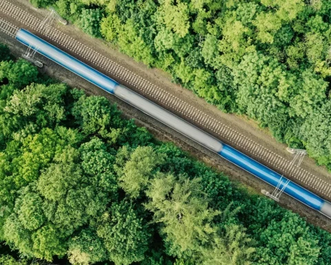 Aerial view of a train driving through a forest. Double track, near Prague, Czech Republic.