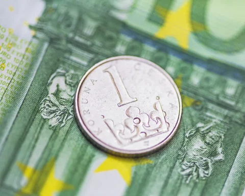 One hundred Euro banknote and Czech Koruna coin.