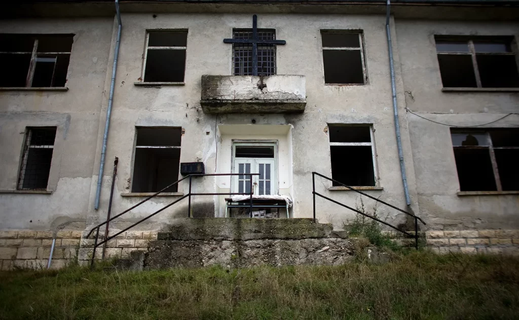 The crumbling building of a communist-era prison built on the site of a former death camp on the Danube island of Persin, northeastern Bulgaria in this October 30, 2009 file photo. Hundreds "enemies of the regime" perished from beatings, malnutrition and exhaustion in 1949-59 in Bulgaria's Belene concentration camp, where dead bodies were fed to pigs. Twenty years after the fall of communism, Belene is largely forgotten - only a small marble plaque tells its horrific story. And nostalgia for the past is growing in the small Balkan country and across the former Soviet bloc.