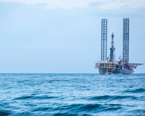Color image of an oil platform on sea, at dusk.