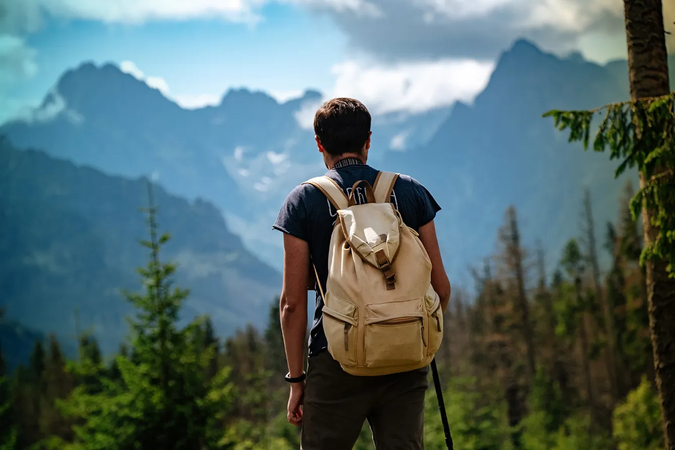 Man hiking at mountains with heavy backpack Travel Lifestyle wanderlust adventure concept summer vacations outdoor alone into the wild. Tatra National Park, Poland.