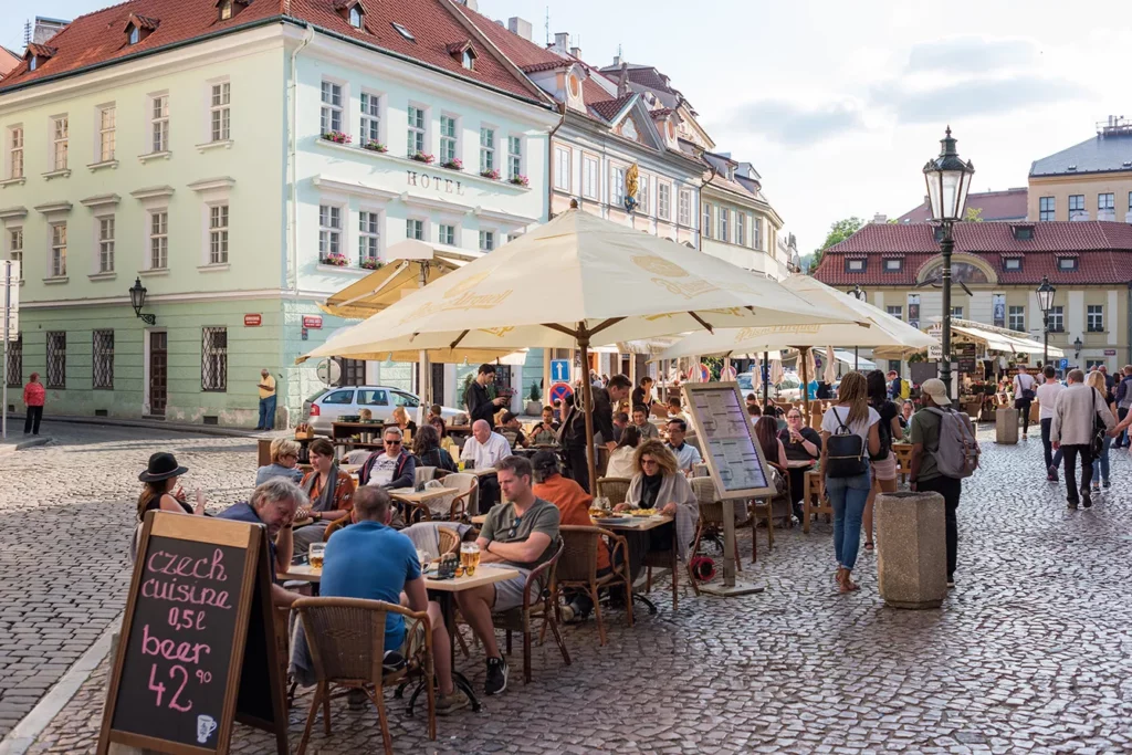 People at outdoor restaurant on city square in Prague, Czech Republic.