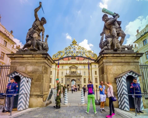 Tourists in front of the Giants Gate (aka Wrestling Giants) in Prague Castle. Prague, Czech Republic