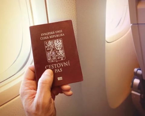Detail of passenger's hand holding passport of the Czech Republic on the airplane.